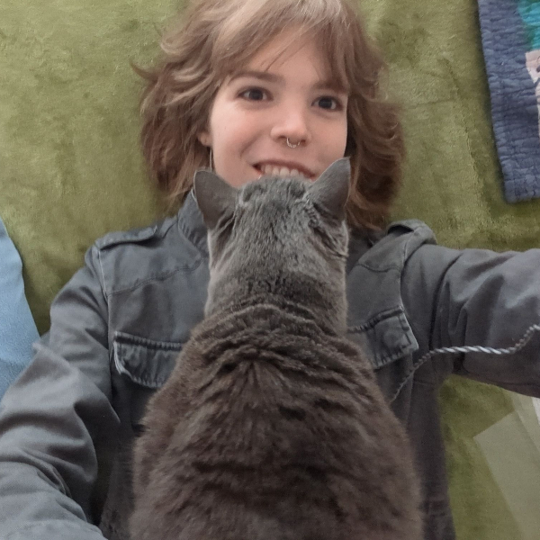 Picture of Ivy with pet cat on chest.